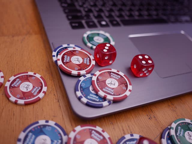Poker-Chips und Würfel auf Laptop